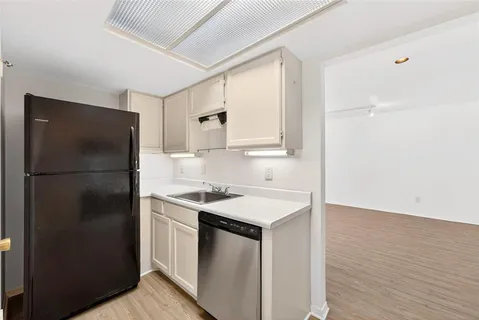 a kitchen with a refrigerator sink and cabinets