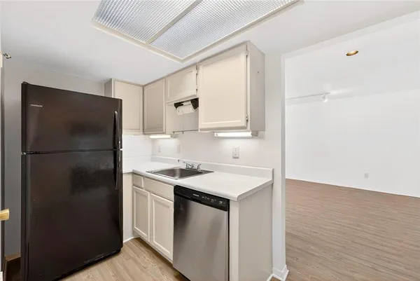 a kitchen with a refrigerator sink and cabinets