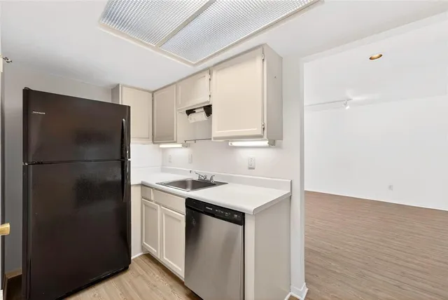 a kitchen with a refrigerator sink and cabinets