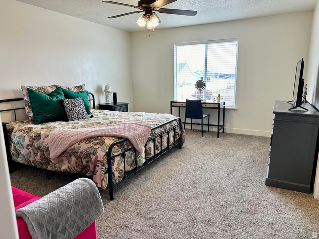 4349 Half Mile Road East Enoch, UT 84721 - Photo 19 of 36 Bedroom with light colored carpet, a textured ceiling, and ceiling fan