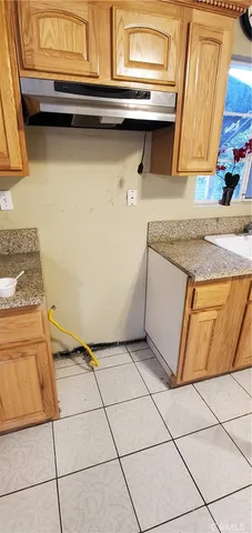 a kitchen with a sink a stove top oven and cabinets