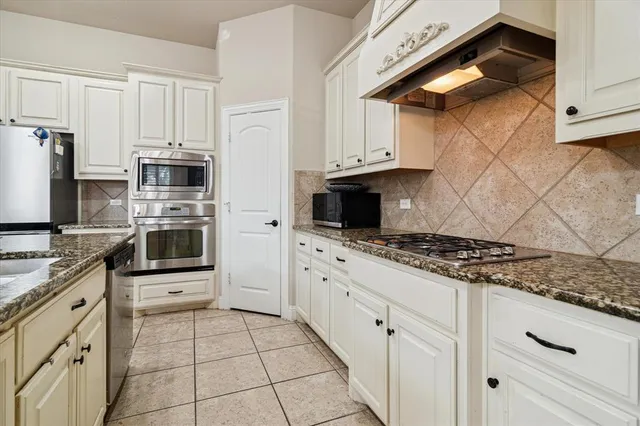 a kitchen with stainless steel appliances a stove microwave and refrigerator