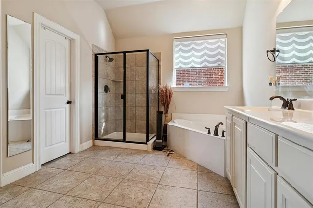 a bathroom with a tub shower sink and mirror