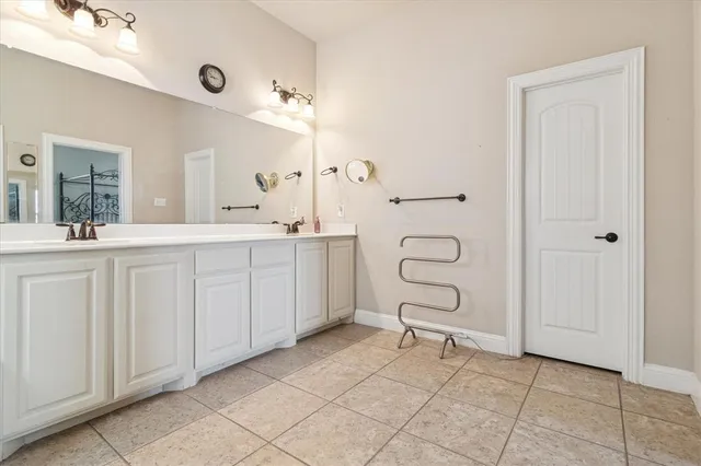 a spacious bathroom with a double vanity sink a mirror and a bathtub