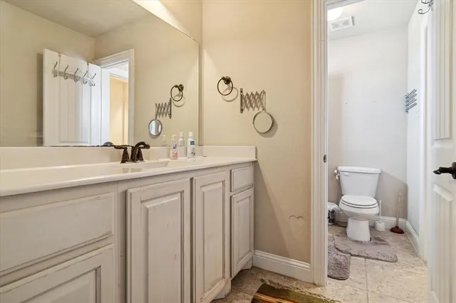 a bathroom with a sink a toilet and a mirror