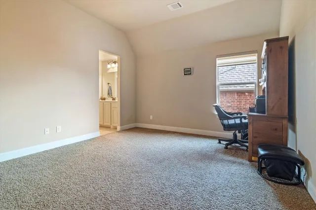 a view of a workspace with furniture and a window