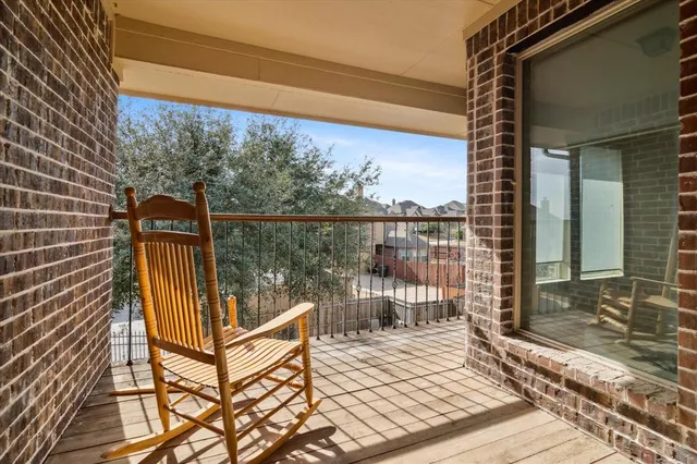 a view of a balcony with wooden floor and fence