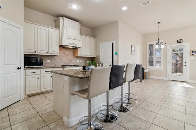 a kitchen with cabinets and chairs