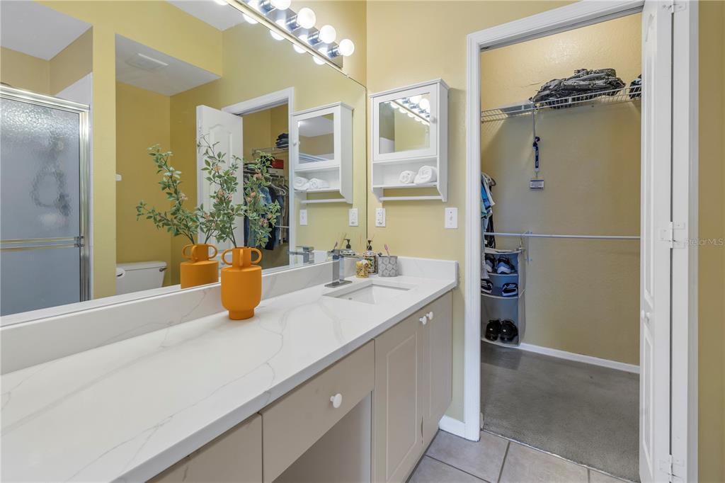 1050 Starkey Road, Unit 2201 Largo, FL 33771 - Photo 55 of 68 a bathroom with a granite countertop sink a mirror and shower