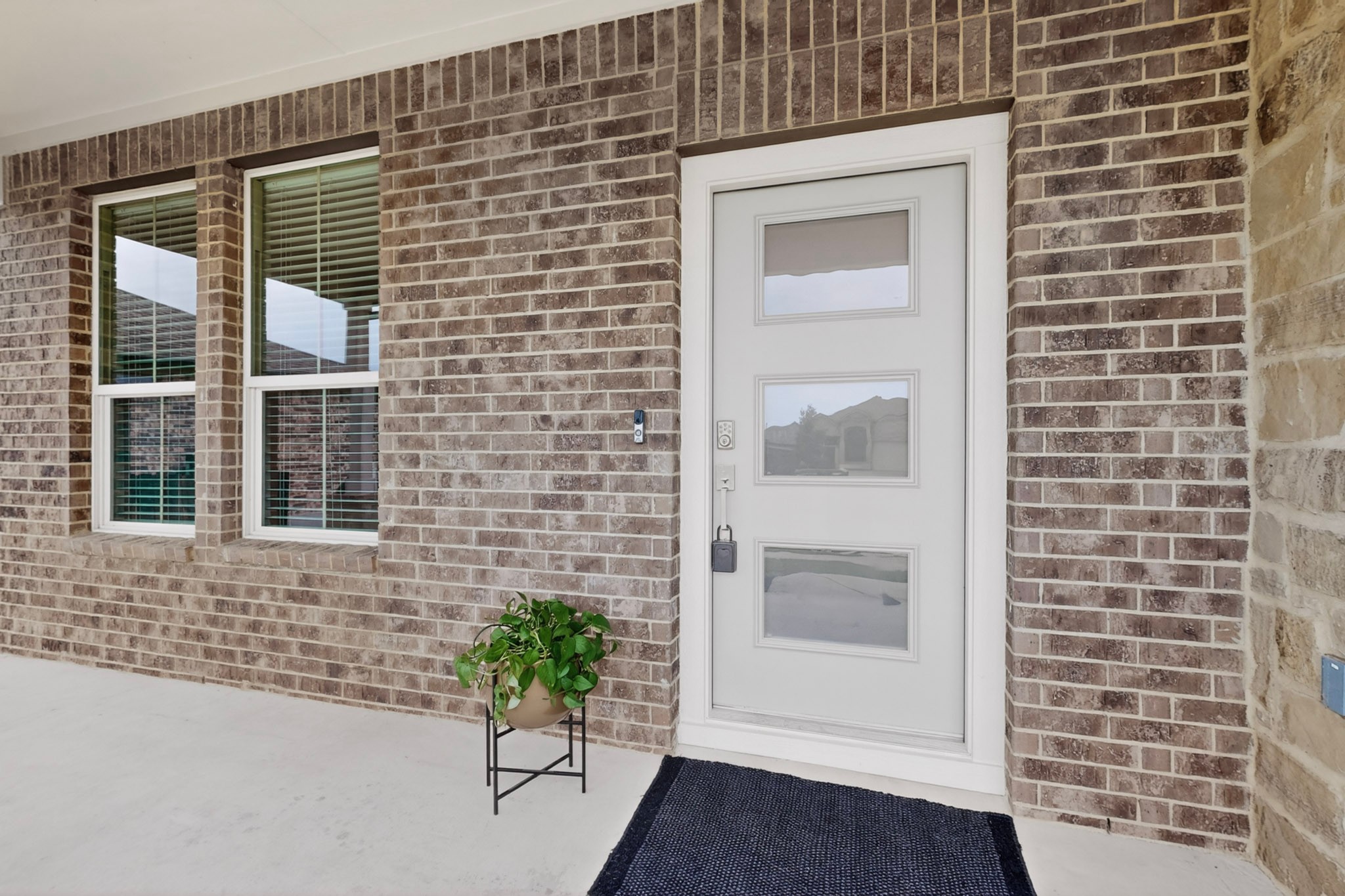 16809 Guido Cove Pflugerville, TX 78660 - Photo 4 of 40 Contemporary front entry featuring a white door with three rectangular lites, surrounded by brick masonry