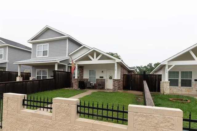 a front view of a house with a yard and trees