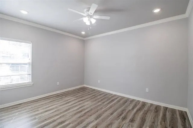 a view of an empty room with window and wooden floor