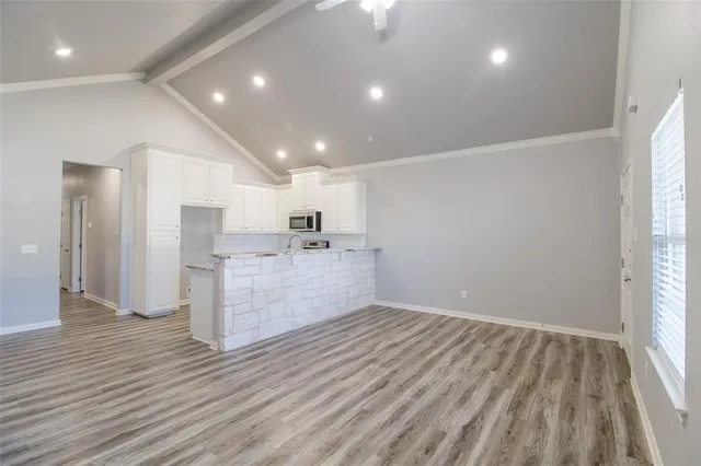 a view of empty room with wooden floor