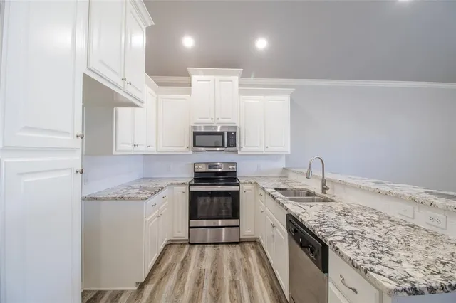 a kitchen with stainless steel appliances granite countertop a sink stove and cabinets