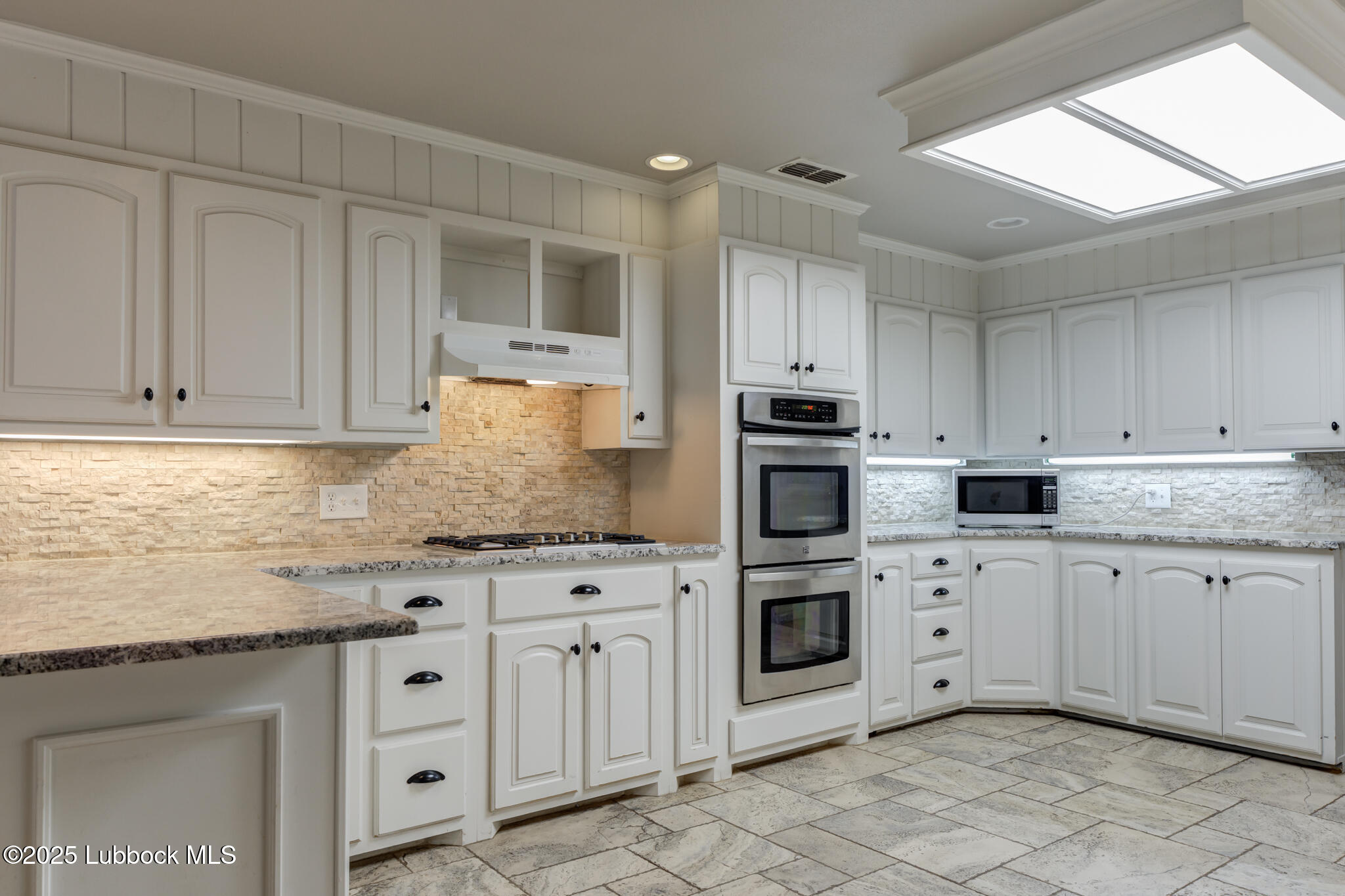 4608 18th Street Lubbock, TX 79416 - Photo 29 of 84 a kitchen with granite countertop white cabinets and stainless steel appliances