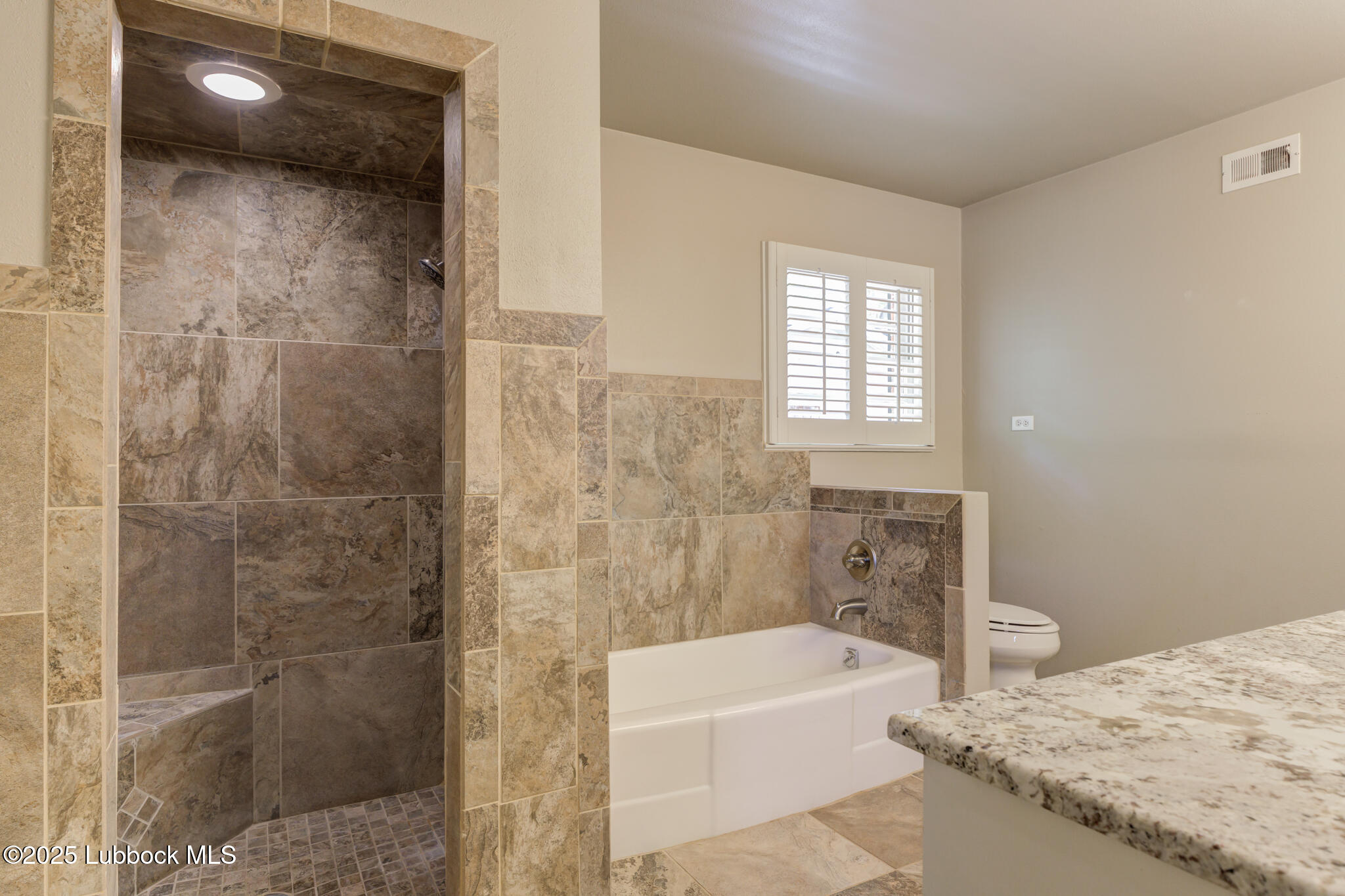 4608 18th Street Lubbock, TX 79416 - Photo 64 of 84 a bathroom with a granite countertop bathtub a sink and a shower