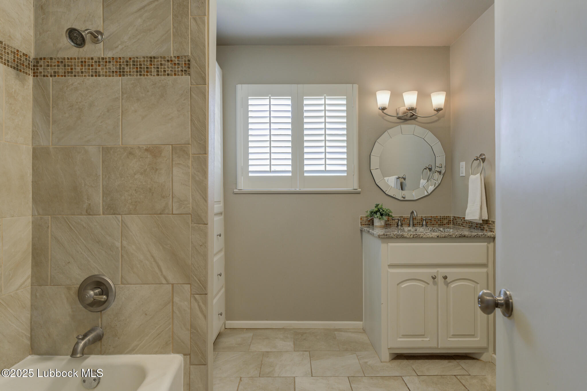 4608 18th Street Lubbock, TX 79416 - Photo 71 of 84 a bathroom with a granite countertop shower a mirror and a sink