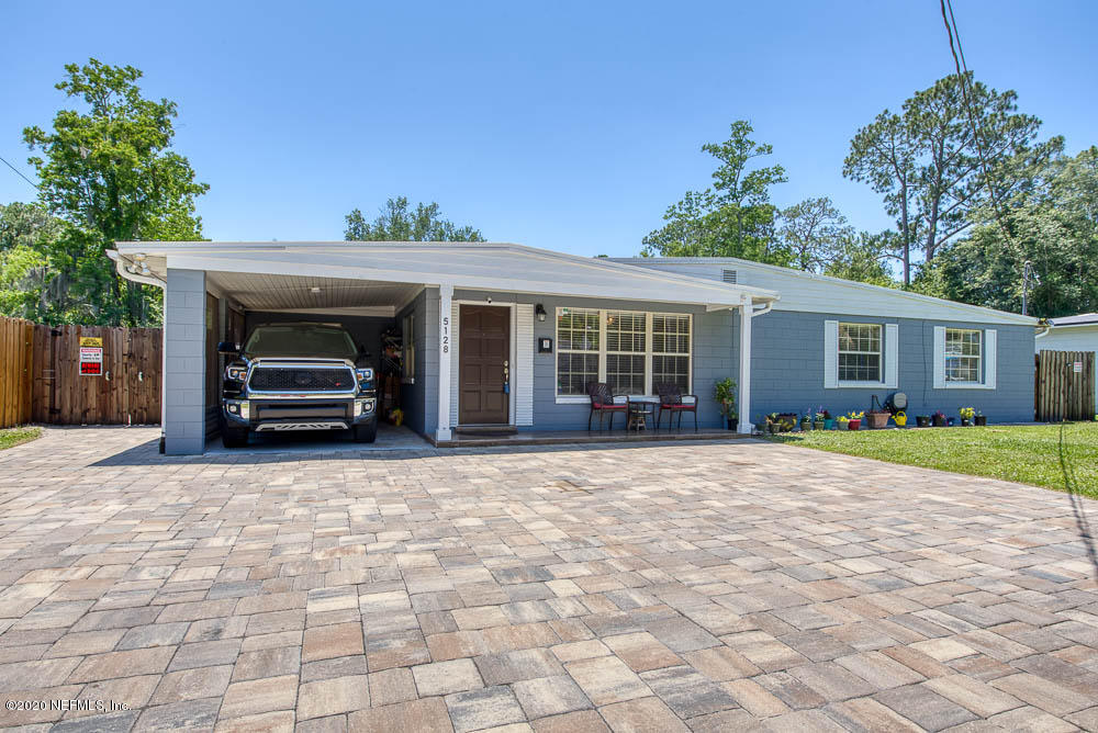 a view of a house with a yard and a garage