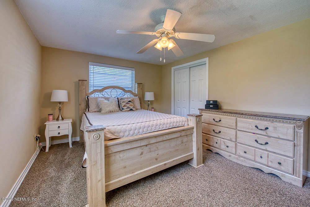 5128 Spring Glen Road Jacksonville, FL 32207 - Photo 13 of 24 a bedroom with a bed and a chandelier