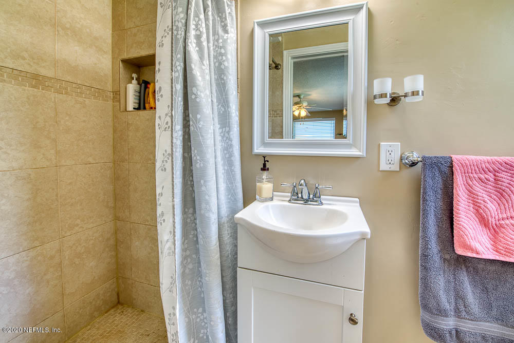 5128 Spring Glen Road Jacksonville, FL 32207 - Photo 14 of 24 a bathroom with a sink and a mirror