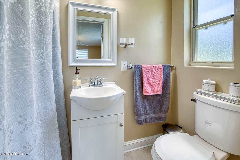5128 Spring Glen Road Jacksonville, FL 32207 - Photo 16 of 24 a bathroom with a toilet sink vanity and mirror