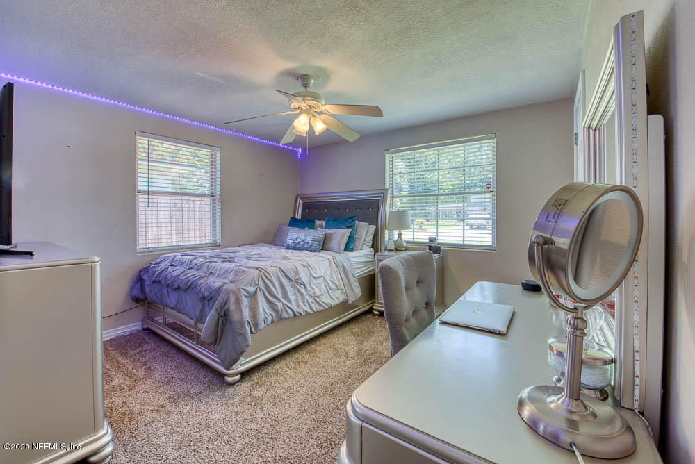 5128 Spring Glen Road Jacksonville, FL 32207 - Photo 17 of 24 a bedroom with a bed mirror and window