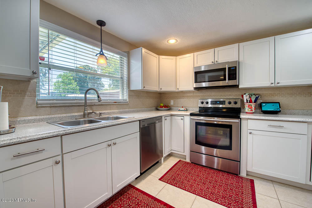 5128 Spring Glen Road Jacksonville, FL 32207 - Photo 7 of 24 a kitchen with a sink stove and microwave