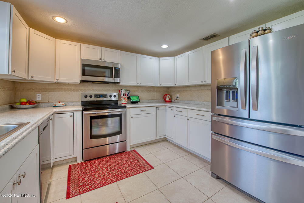 5128 Spring Glen Road Jacksonville, FL 32207 - Photo 8 of 24 a kitchen with stainless steel appliances granite countertop a refrigerator sink and stove