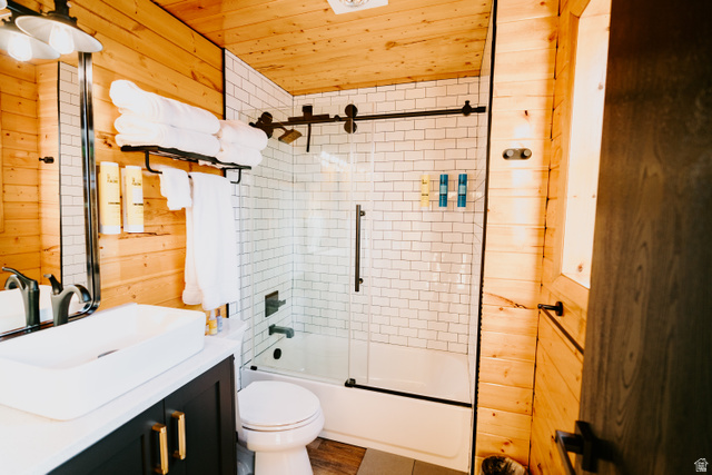 1413 Basel Drive Midway, UT 84049 - Photo 43 of 137 Bathroom with wooden walls, bath / shower combo with glass door, vanity, and wooden ceiling