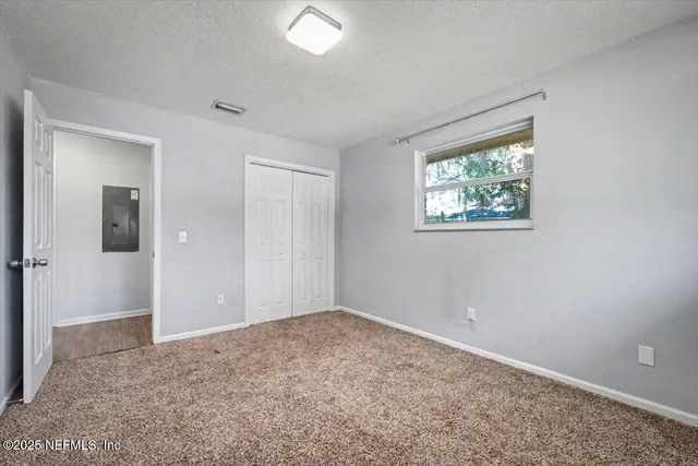 an empty room with windows and closet