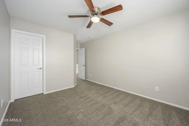 an empty room with a window and a fan