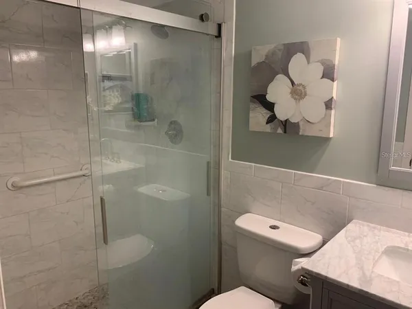 a bathroom with a sink a toilet and a shower