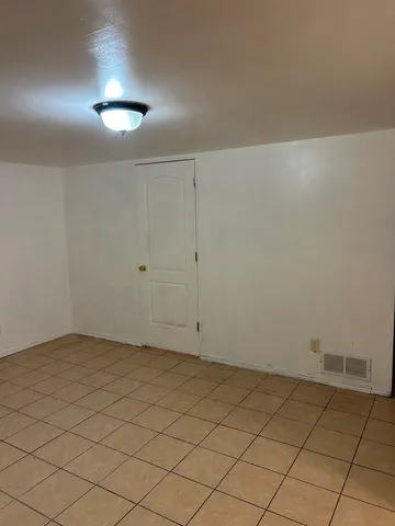 an empty room with a wooden cabinet and a window