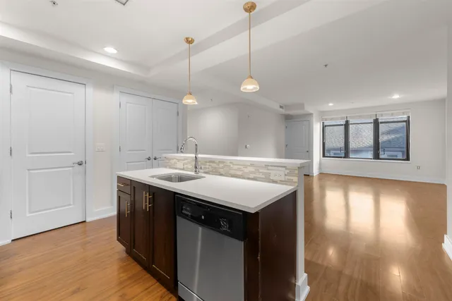 a kitchen with a sink and a wooden floor