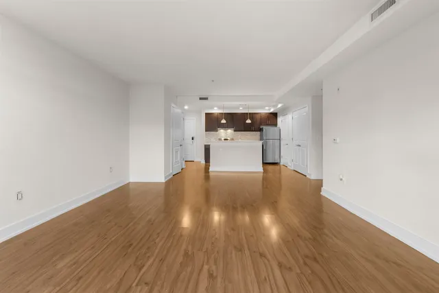 a view of empty room with wooden floor