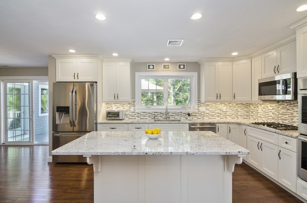 a kitchen with stainless steel appliances granite countertop a kitchen island a stove and a sink