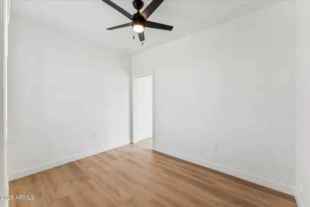 an empty room with a fan and a window