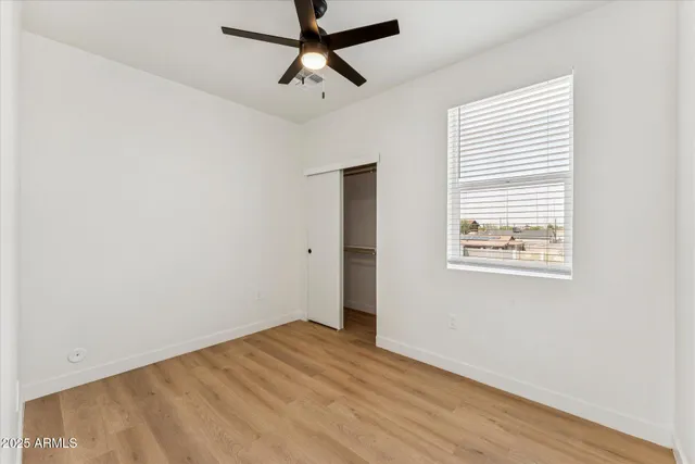 an empty room with a window and a fan