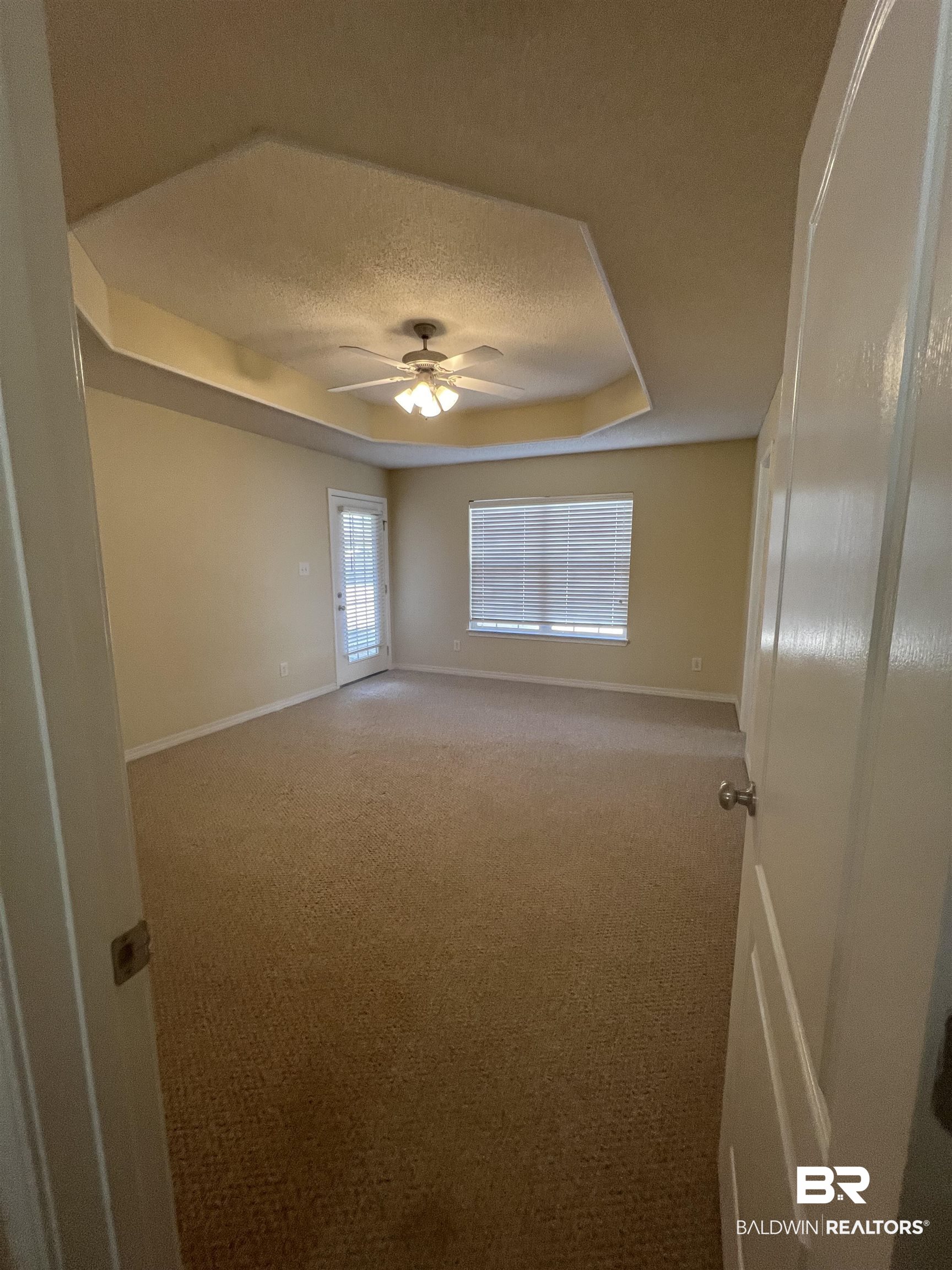 17793 Fancy Boulevard Foley, AL 36535 - Photo 15 of 34 Spare room with ceiling fan, a raised ceiling, carpet floors, and a textured ceiling