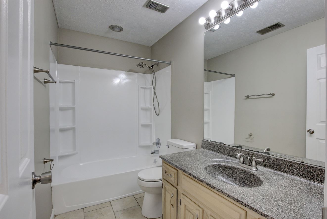 1105 Bark Ridge Circle Hopkinsville, KY 42240 - Photo 20 of 29 a bathroom with a granite countertop sink a toilet a mirror and shower