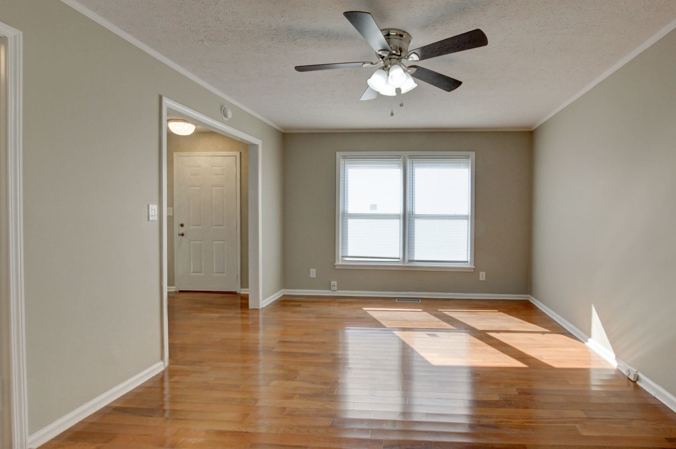 1105 Bark Ridge Circle Hopkinsville, KY 42240 - Photo 21 of 29 an empty room with wooden floor chandelier fan and windows