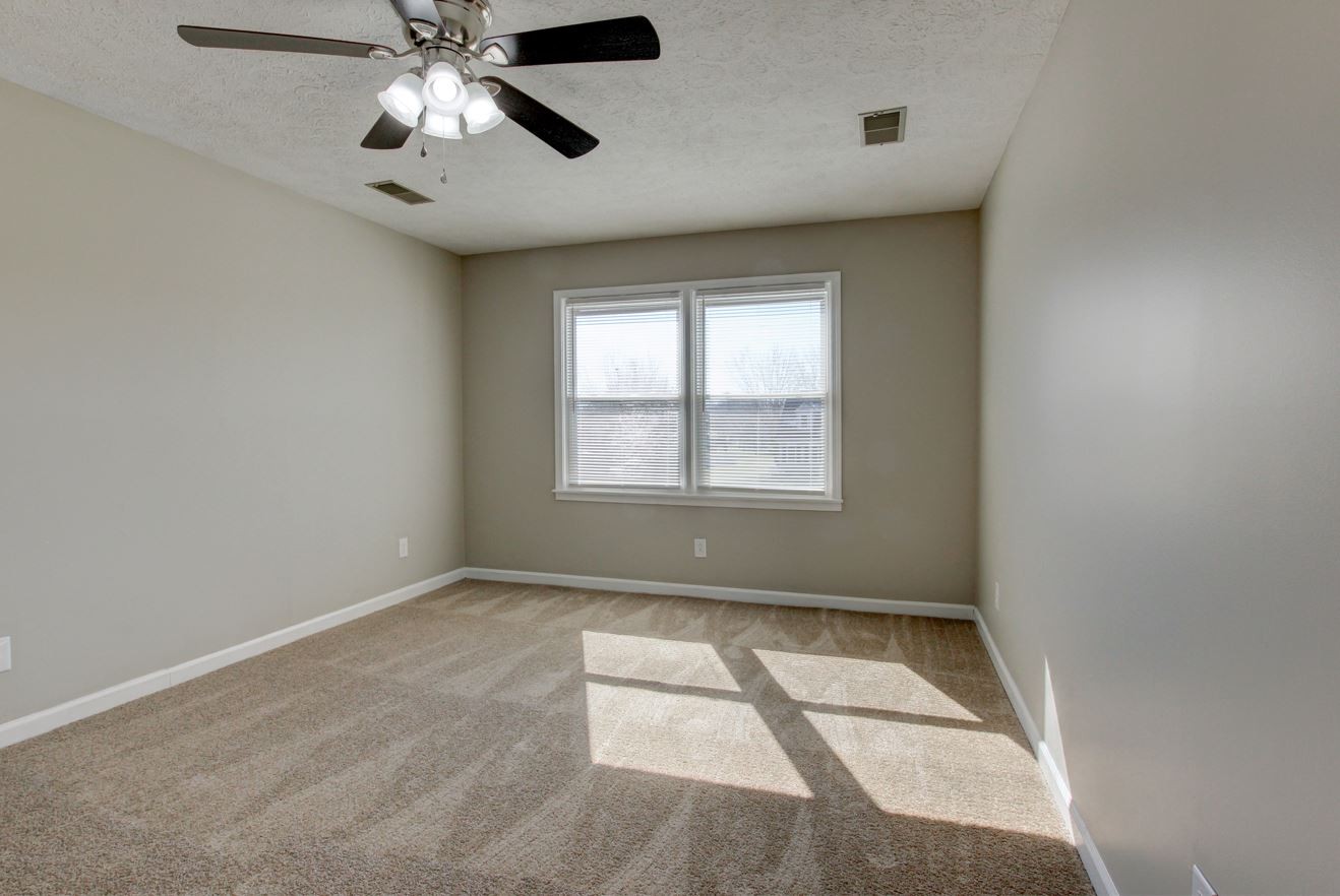 1105 Bark Ridge Circle Hopkinsville, KY 42240 - Photo 6 of 29 an empty room with a chandelier fan and windows
