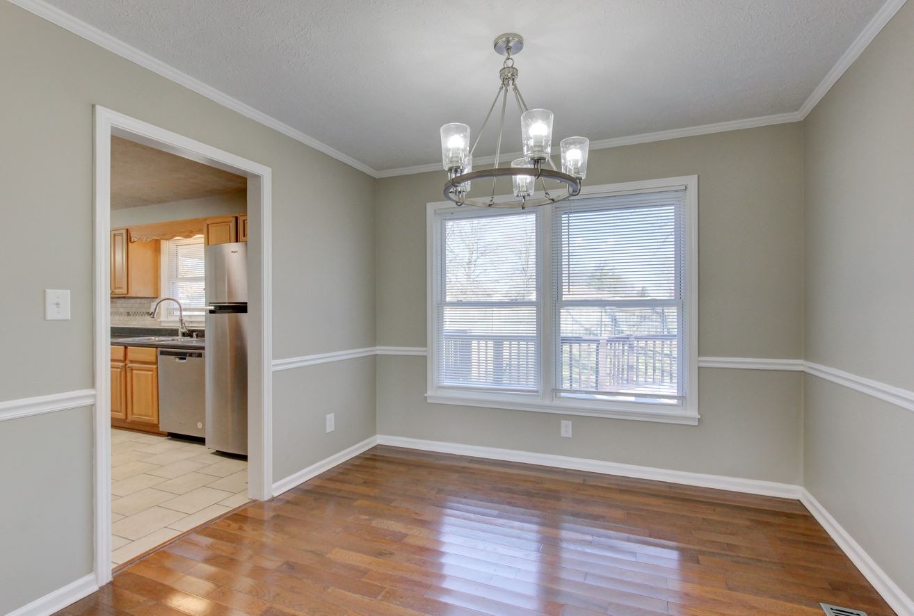 1105 Bark Ridge Circle Hopkinsville, KY 42240 - Photo 9 of 29 an empty room with wooden floor chandelier and windows