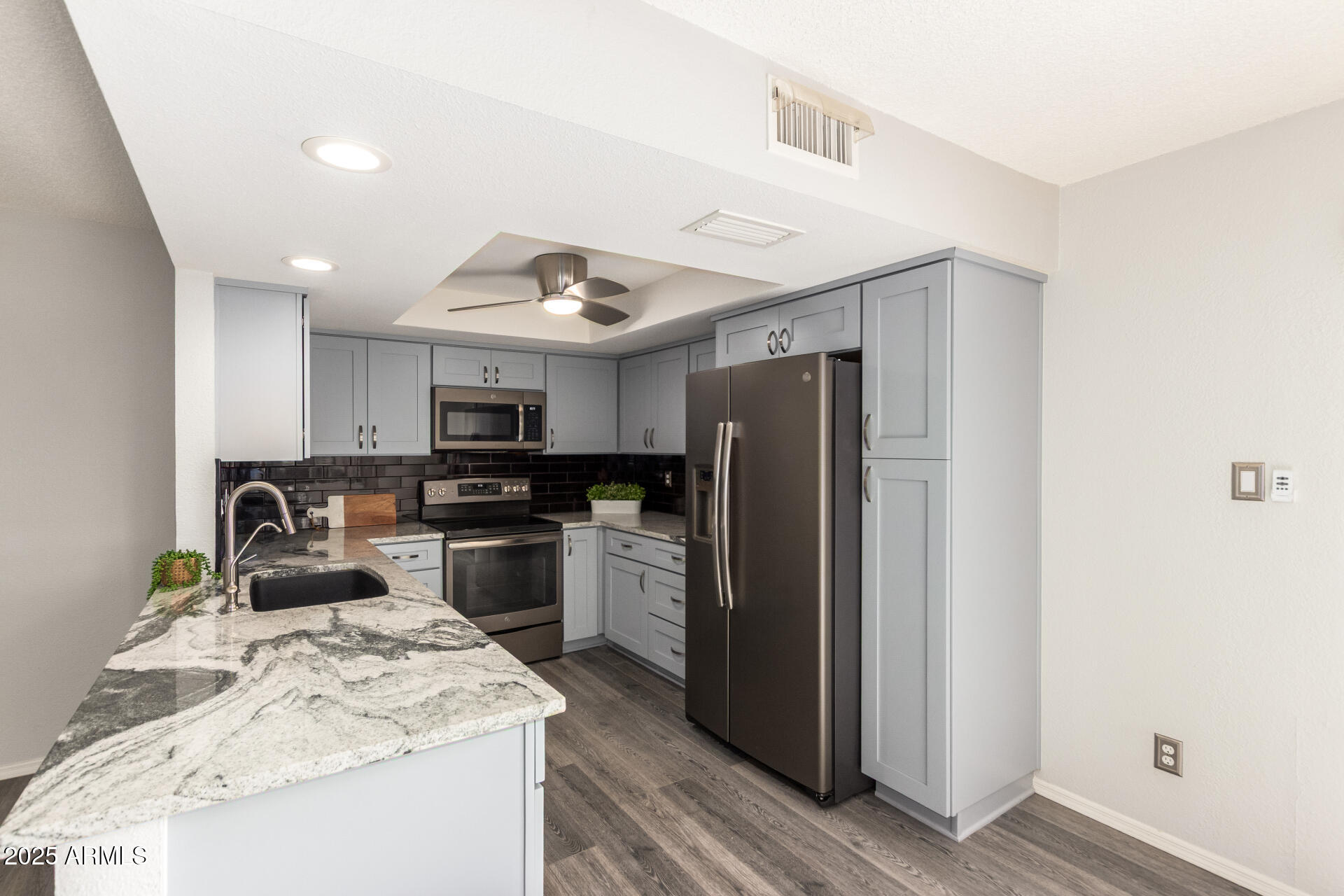 716 South Privet Way Mesa, AZ 85208 - Photo 13 of 40 a kitchen with stainless steel appliances granite countertop a refrigerator a stove and a sink with wooden floor