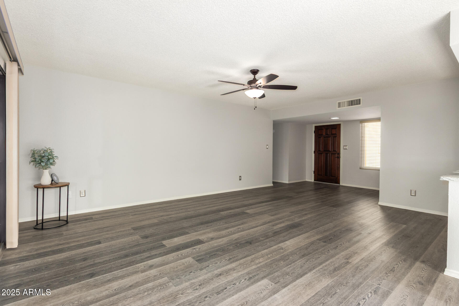 716 South Privet Way Mesa, AZ 85208 - Photo 7 of 40 a view of an empty room with wooden floor and a window