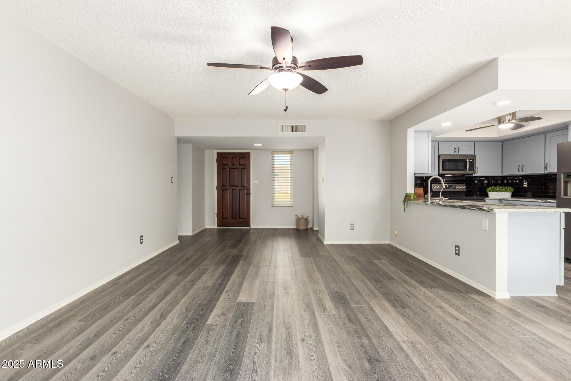 716 South Privet Way Mesa, AZ 85208 - Photo 9 of 40 a view of a kitchen with wooden floor and a ceiling fan
