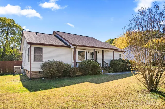 a front view of house with yard and trees around