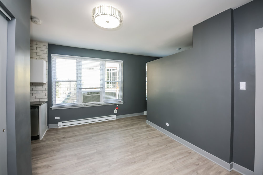 944 West Montrose Avenue, Unit 309 Chicago, IL 60613 - Photo 5 of 9 an empty room with wooden floor and windows