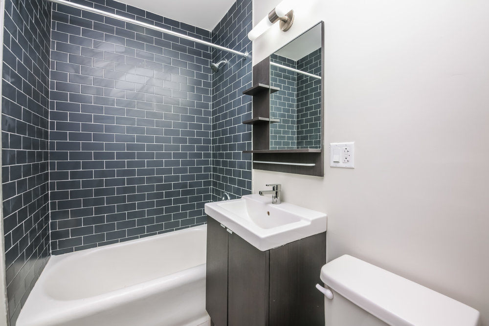 944 West Montrose Avenue, Unit 309 Chicago, IL 60613 - Photo 7 of 9 a bathroom with a sink mirror bathtub and toilet