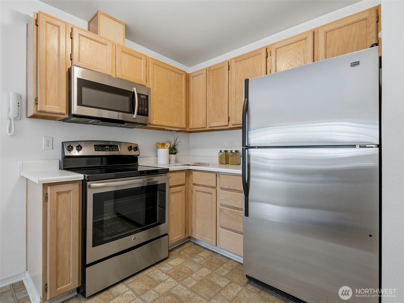 1733 Northwest 59th Street, Unit 301 Seattle, WA 98107 - Photo 7 of 35 a kitchen with stainless steel appliances white cabinets and a refrigerator